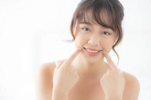 Beautiful portrait young asian woman smiling healthy and wellness at bedroom, beauty asia girl skin care touch teeth makeup and cosmetic with happy with fresh, lifestyle and relax concept. photo