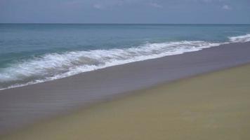 olas turquesas rodaron en la arena de la playa, playa mai khao, phuket, cámara lenta video