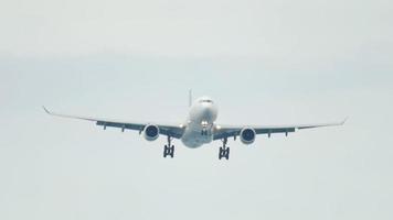 impresionante aterrizaje de avión volando por encima. avión de línea aérea comercial volando por encima de la cabeza en un día soleado y azul del cielo video