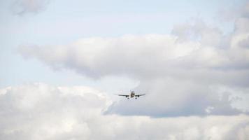 avión de pasajeros en el fondo de nubes espesas vuela para aterrizar en el aeropuerto. concepto de viaje