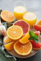 Glasses of juice and citrus fruits photo