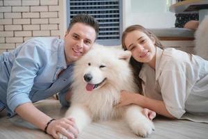 Man and girl with his pet dog playing on the floor. Happy dog, happy guy with dog. photo