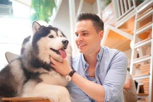 hombre y con su perro mascota jugando en el suelo. perro feliz, chico feliz con perro. foto