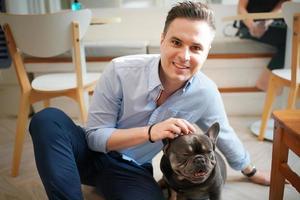 Man and with his pet dog playing on the floor. Happy dog, happy guy with dog. photo