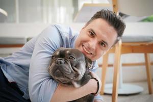 Man and with his pet dog playing on the floor. Happy dog, happy guy with dog. photo