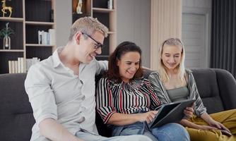 Happy caucasian family using tablet, laptop, phone for playing game watching movies, relaxing at home for technology lifestyle concept