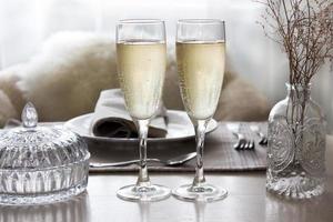 Pair of filled champagne flutes on the wedding table, mockup photo