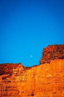 Moon rising over red cliffs photo