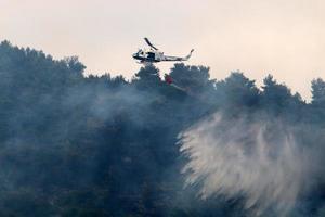 un helicóptero de la onu apaga un incendio en un bosque en la frontera entre israel y el líbano. foto