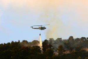 un helicóptero de la onu apaga un incendio en un bosque en la frontera entre israel y el líbano. foto