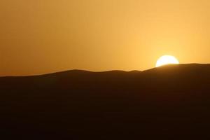 Sunrise on the Dead Sea from behind the mountains in Jordan photo