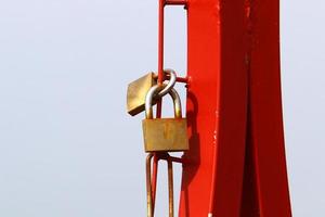 An iron padlock hangs on a closed gate photo