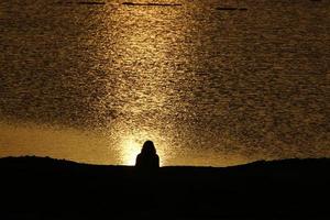 amanecer en el mar muerto desde detrás de las montañas en jordania foto