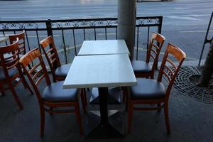 mesa y sillas en un café en un parque de la ciudad foto