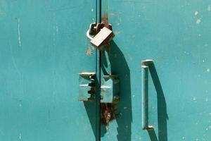un candado de hierro cuelga de una puerta cerrada foto