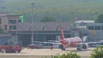 phuket, tailandia 29 novembre 2019 - aereo passeggeri airbus a320 di airasia al terminal dell'aeroporto in manutenzione. vista sul piazzale dell'aeroporto di phuket. video