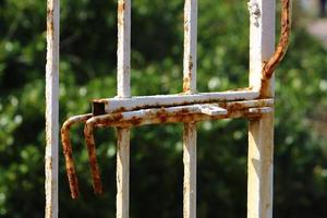 An iron padlock hangs on a closed gate photo
