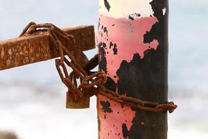 An iron padlock hangs on a closed gate photo