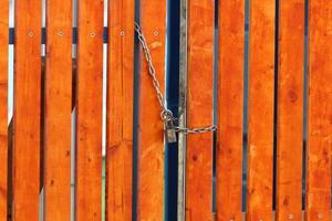 An iron padlock hangs on a closed gate photo