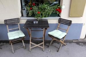 mesa y sillas en un café en un parque de la ciudad foto