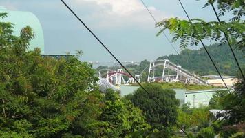 SENTOSA ISLAND, SINGAPORE NOVEMBER 24, 2018 - Roller Coaster attraction at Sentosa resort island and cable car cabins at foreground video