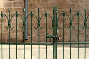 An iron padlock hangs on a closed gate photo