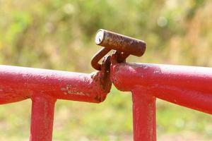 An iron padlock hangs on a closed gate photo