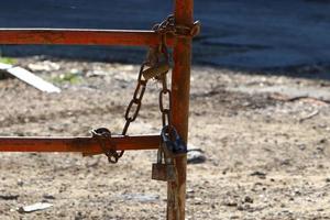 An iron padlock hangs on a closed gate photo