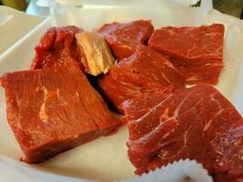 grandes trozos de carne de res roja cruda en un recipiente de espuma foto