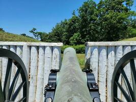 metal cannon artillery with wheels and fort wall photo