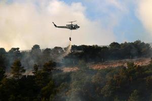 A UN helicopter puts out a fire in a forest on the Israel-Lebanon border. photo