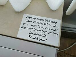 Por favor, mantenga el letrero de la puerta del balcón cerrada en la unidad de aire acondicionado. foto