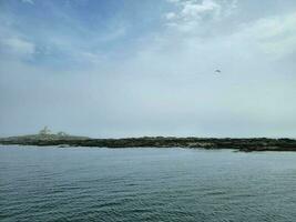 lighthouse and rocky shore on the coast of Maine photo