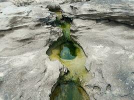 hole in grey rock at beach and water in Puerto Rico photo