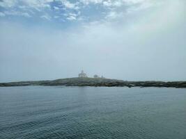 lighthouse and rocky shore on the coast of Maine photo