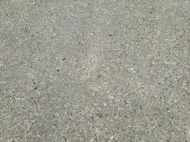pebbles and rocks in the grey cement on the ground or floor photo