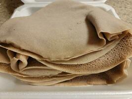 foam container with stack of Ethiopian bread called injera photo