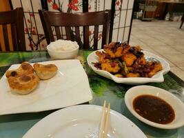 hot and spicy Chinese fried fish with peppers and dumplings photo