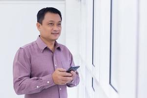 Asian business man is holding smartphone photo