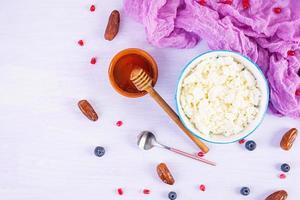 Cottage cheese with honey and berries on pink background. Light vegetarian breakfast. Top view photo