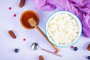 Cottage cheese with honey and berries on pink background. Light vegetarian breakfast. Top view photo