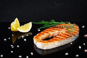 pescado salmón a la parrilla en tablero de piedra. salmón atlántico a la sal frito a la parrilla con limón