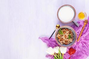 Spelt flakes with milk on breakfast. Light breakfast on Valentine's day with tulips and heart photo