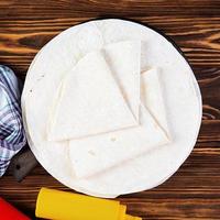 Round lavash on a wooden background. Isolated pita bread photo