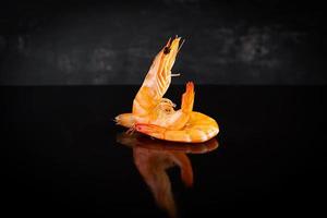 Delicious cooked shrimps isolated on dark background. Boiled prawns photo