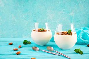 Sweet milk pudding with almonds and chocolate chips on blue background photo