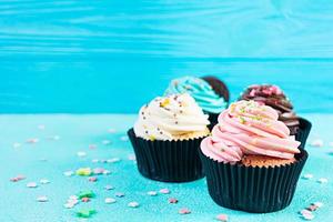 Tasty colorful cupcakes isolated on blue background. Delicious cupcake photo