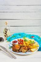 Delicious baked chicken with potatoes on wooden background