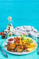 Delicious baked chicken with potatoes on blue background
