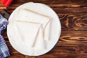 Round lavash on a wooden background. Isolated pita bread photo